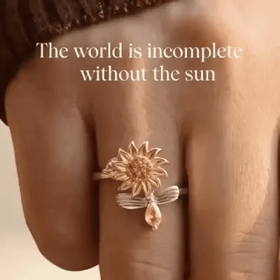 Anillo giratorio girasol color dorado con circonita brillante, ajustable, sobre fondo suave | Pillaca